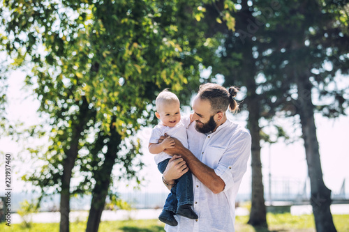 Family father and baby happy and beautiful with smiles together in the Park walking summer portrait © kuzmichstudio