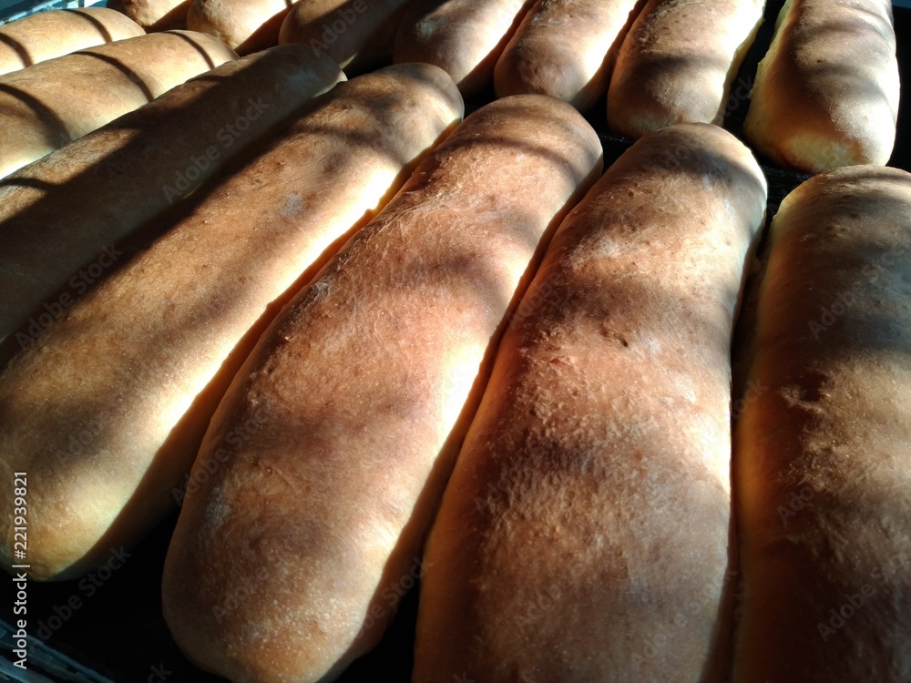 Fresh pastry, long buns on a roasting pan