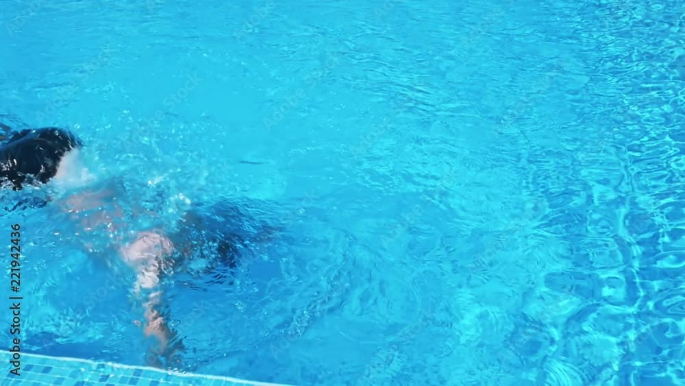 Man walking in the swimming pool on sunny day Man walking in the swimming pool on sunny day