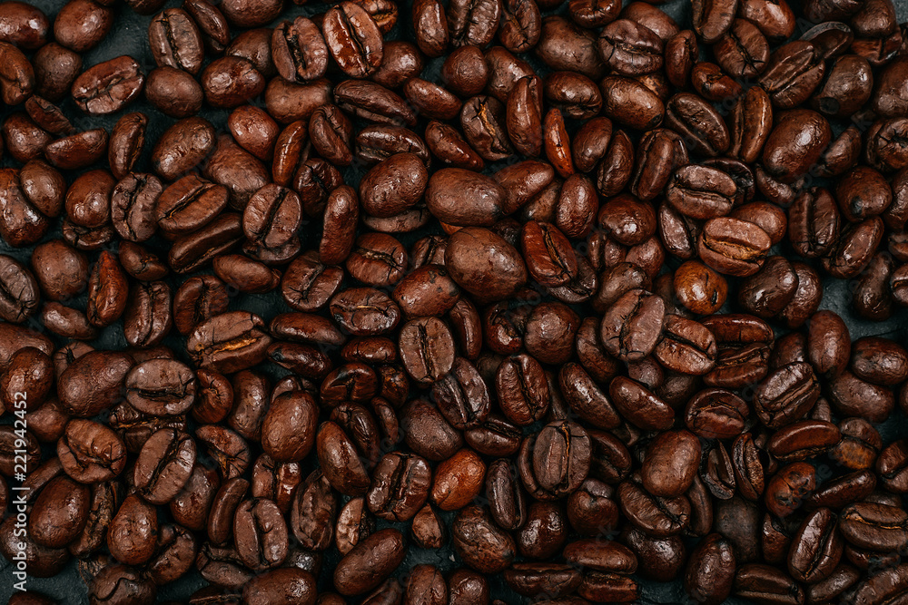 Naklejka premium Roasted brown coffee beans background. Flatlay style, messy pattern.