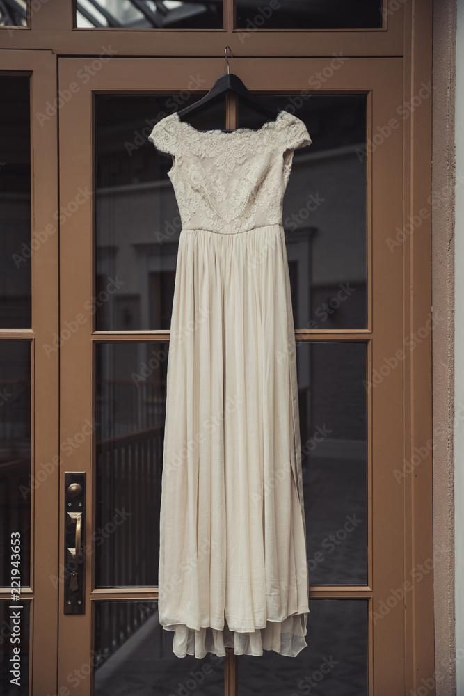 White wedding dress hanging over the door White wedding dress hanging over the door