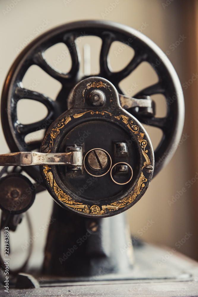 Obraz premium Wedding rings on an old sewing machine