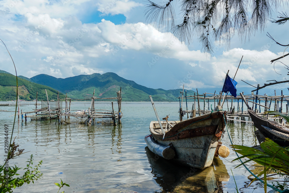Rustic old boat floating a tranquil bay in rural Vietnam