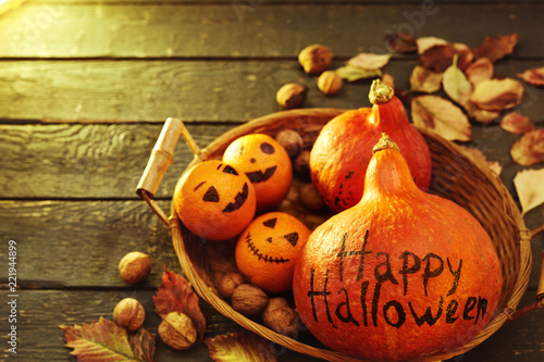 set for Halloween from a pumpkin with an inscription and painted oranges in a wicker basket photo