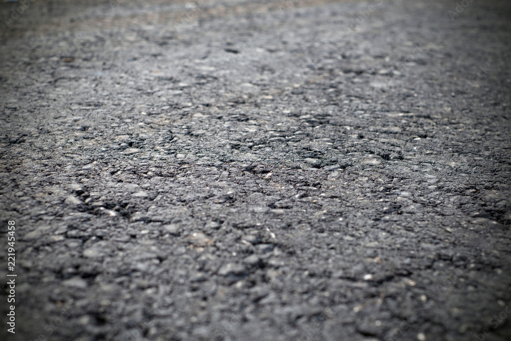 A dark grey asphalt pavement texture. Сlose-up of the repair of the road. A dark grey asphalt pavement texture. Сlose-up of the repair of the road.