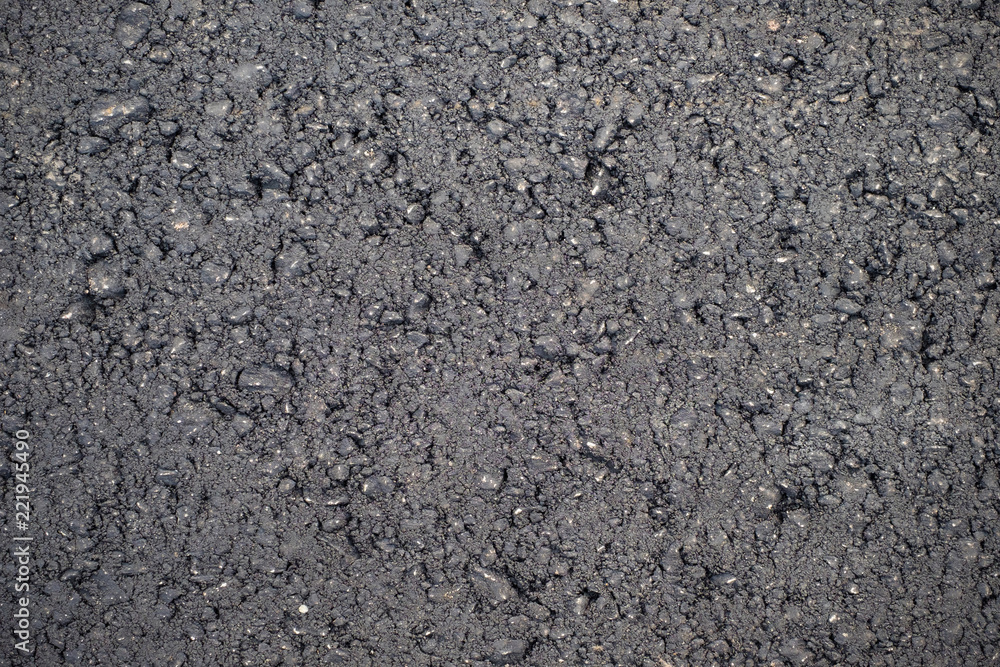 A dark grey asphalt pavement texture. Сlose-up of the repair of the road. A dark grey asphalt pavement texture. Сlose-up of the repair of the road.