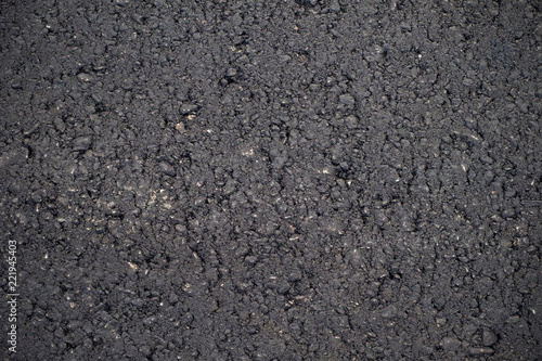 A dark grey asphalt pavement texture. Сlose-up of the repair of the road.