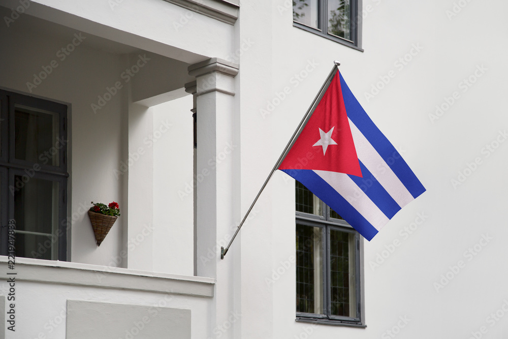 Cuba flag.  Cuba flag hanging on a pole in front of the house. National flag of waving on a home displaying on a pole on a front door of a building. Flag raised at a full staff.