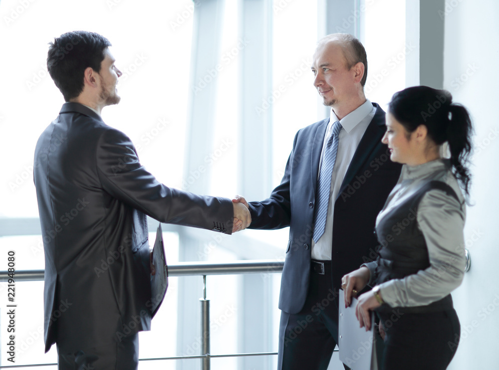 smiling business team looking at a financial chart smiling business team looking at a financial chart