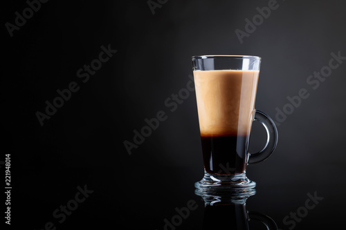 Coffee drink or cocktail with cream on a black background.