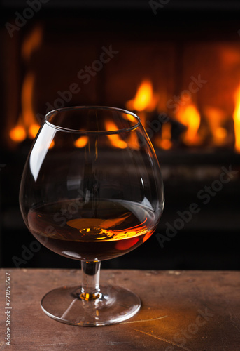 a glass of cognac in front of fireplace