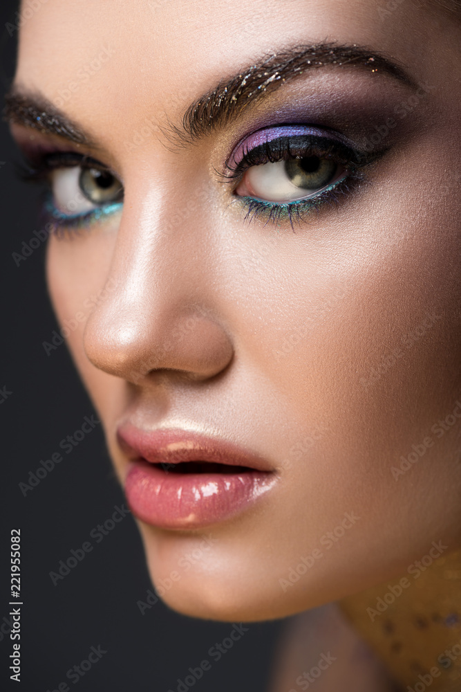 close up of young model with glitter makeup on face, isolated on grey close up of young model with glitter makeup on face, isolated on grey