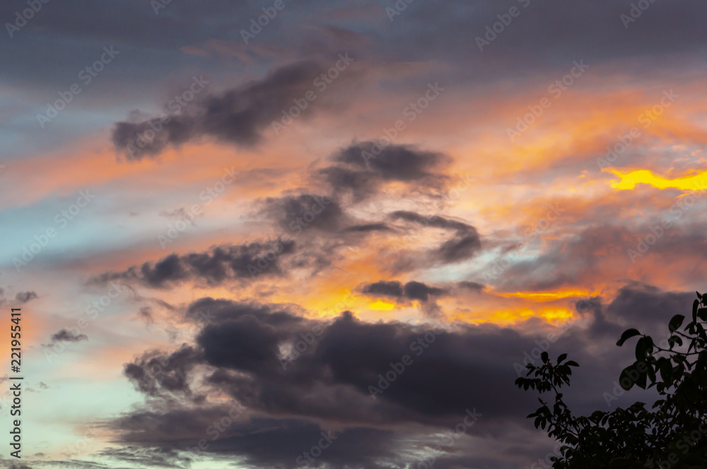 Blue sky at sunset with colorful clouds. Blue, blue, orange, gray, black and purple colors of the sky and clouds. Nature concept for design