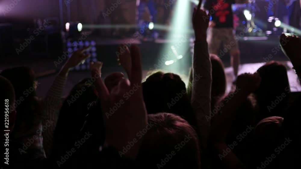 Dancing cheering crowd fan spectators rais hands up in air at concert lumiere