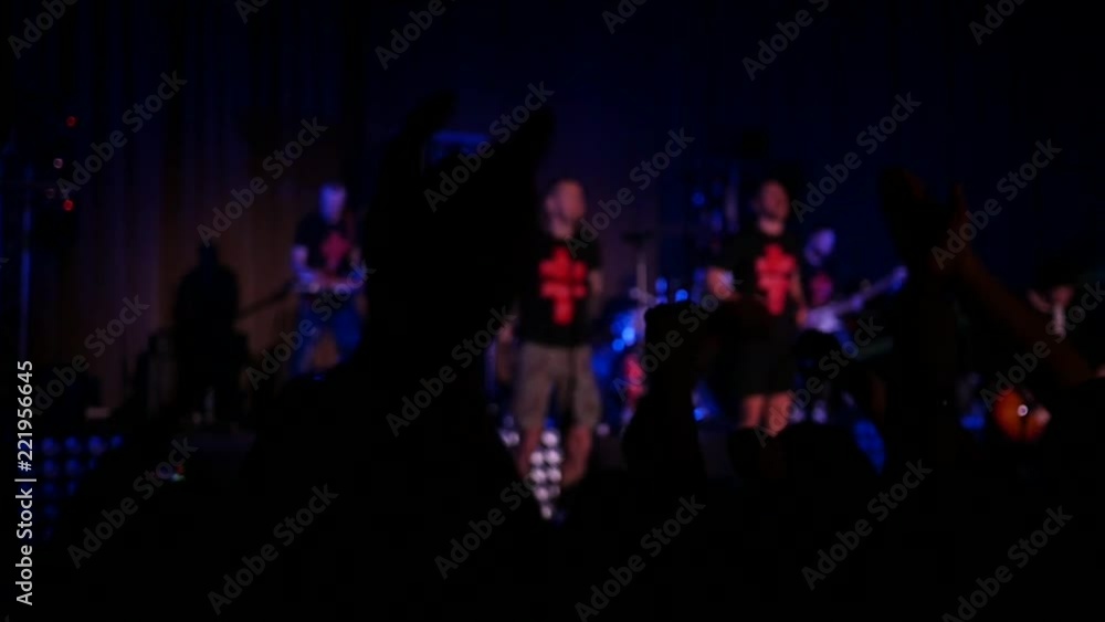 Dancing cheering crowd fan spectators rais hands up in air at concert lumiere