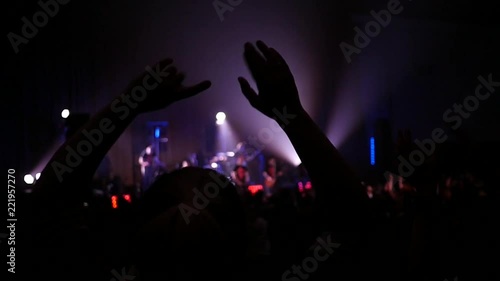 Dancing girls fan silhouettes enjoying a music concert at flashing lumiere photo