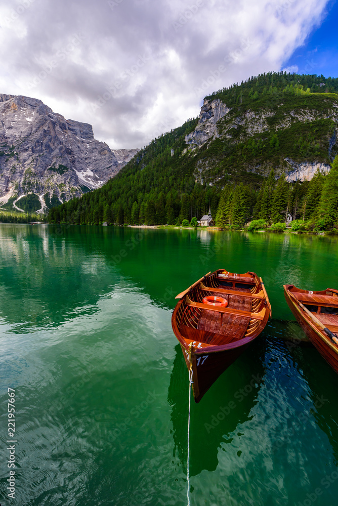 Lake Braies (also known as Pragser Wildsee or Lago di Braies) in Dolomites Mountains, Sudtirol, Italy. Romantic place with typical wooden boats on the alpine lake.  Hiking travel and adventure.