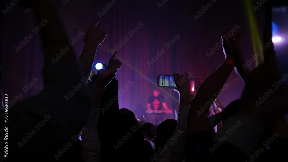 Cheering crowd fan spectators silhouettes rais hands at concert lumiere