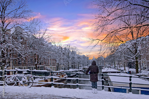 Amsterdam covered with snow  in winter in the Netherlands at sunset