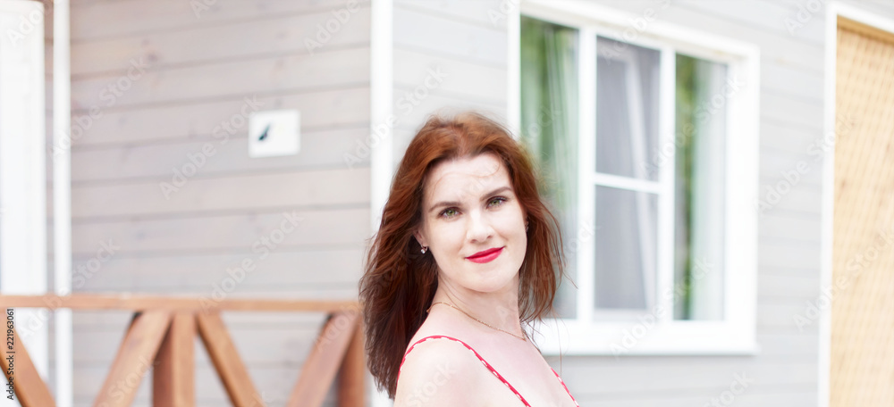 Banner girl Face brunette on the background of wooden village houses Beautiful girl smiling Banner girl Face brunette on the background of wooden village houses Beautiful girl smiling