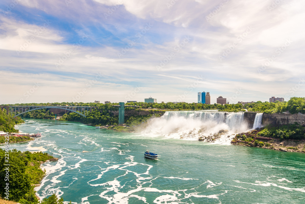 View at the Rainbow International bridge over Niagara river with American falls and Bridal Veil falls at USA territory from Niagara falls town in Canada View at the Rainbow International bridge over Niagara river with American falls and Bridal Veil falls at USA territory from Niagara falls town in Canada