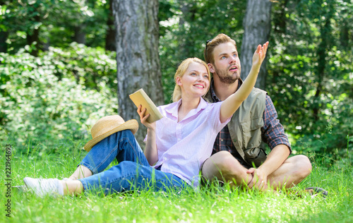 Couple in love spend leisure in park or forest. Romantic couple students enjoy leisure looking upwards observing nature background. Romantic date at green meadow. Couple soulmates at romantic date