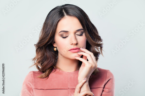 Beautiful woman brunette with makeup and manicured hand, closed eyes. Pink lips and nails
