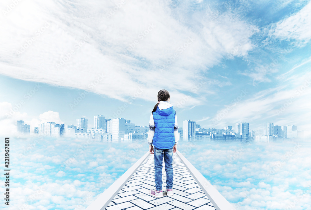 Mirage and fantasy. A little girl stands on the road to a mystical city in the sky among the clouds