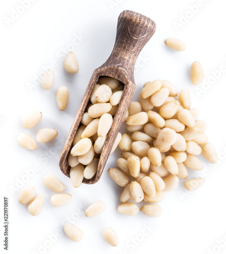 Εκτύπωση καμβά Pine nuts in the wooden scoop. White background.