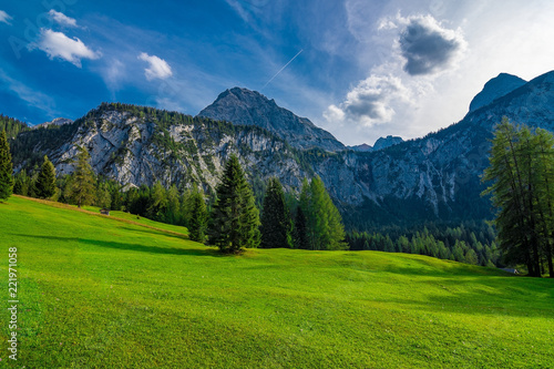 A beautiful view on some mountains, forest and pasture on a sunny summer day in Austria, September 2018