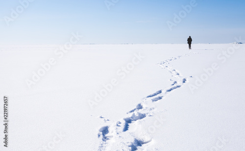 Footsteps of lonely person walking on snow