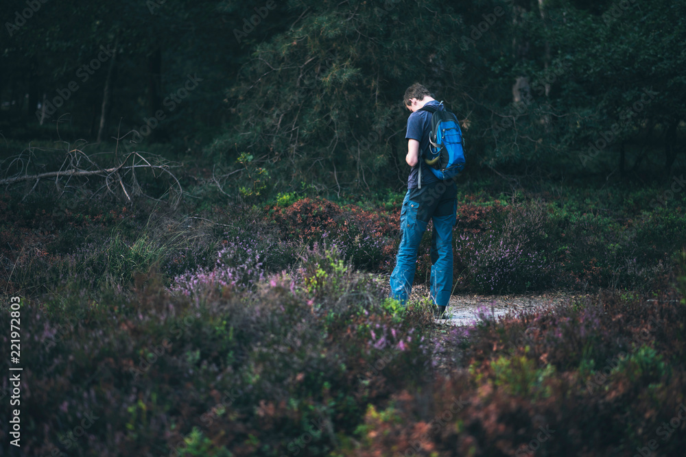 Man with backpack outdoors in moorland. Rear view. Man with backpack outdoors in moorland. Rear view.
