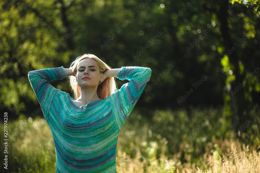 Sweet beautiful woman posing with her hands at back of her head. Gorgeous woman out in nature about to flip her blond hair back with both of her hands. Sweet beautiful woman posing with her hands at back of her head. Gorgeous woman out in nature about to flip her blond hair back with both of her hands.