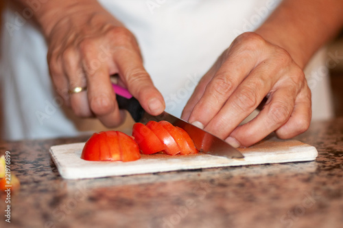 Frau schneidet friesche Tomaten für einen Salat