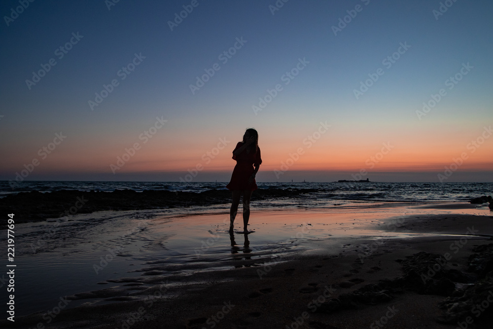Girl watching the sunset at the beach