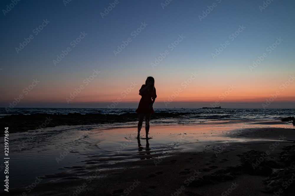Girl watching the sunset at the beach Girl watching the sunset at the beach