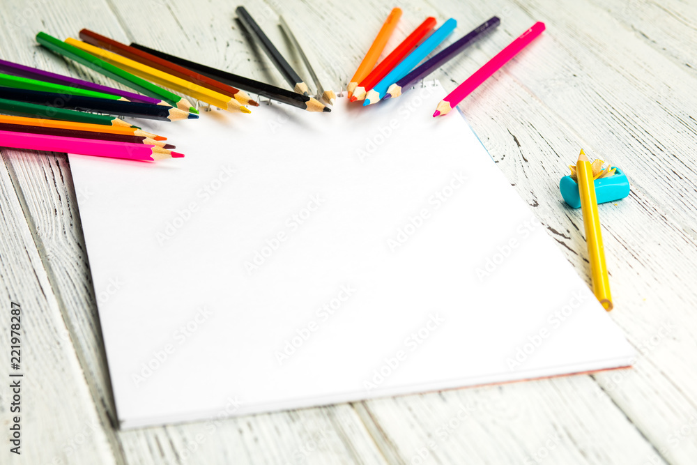 Art album and colored pencils on old wooden boards. Art album and colored pencils on old wooden boards.
