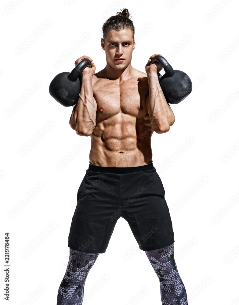 Young muscular guy training with kettlebells. Photo of sporty model with naked torso and good physique on white background. Strength and motivation Young muscular guy training with kettlebells. Photo of sporty model with naked torso and good physique on white background. Strength and motivation
