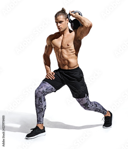 Sportive man workout with kettlebell doing lunges. Photo of handsome man with good physique isolated on white background. Strength and motivation