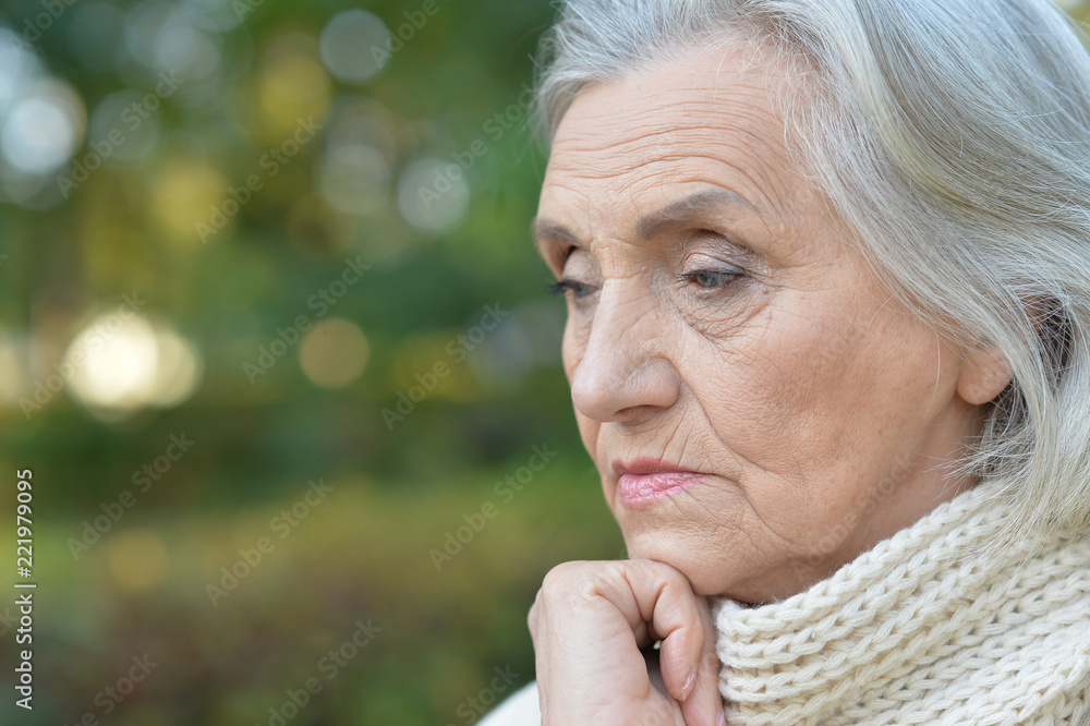Portrait of sad senior woman in autumn park Portrait of sad senior woman in autumn park