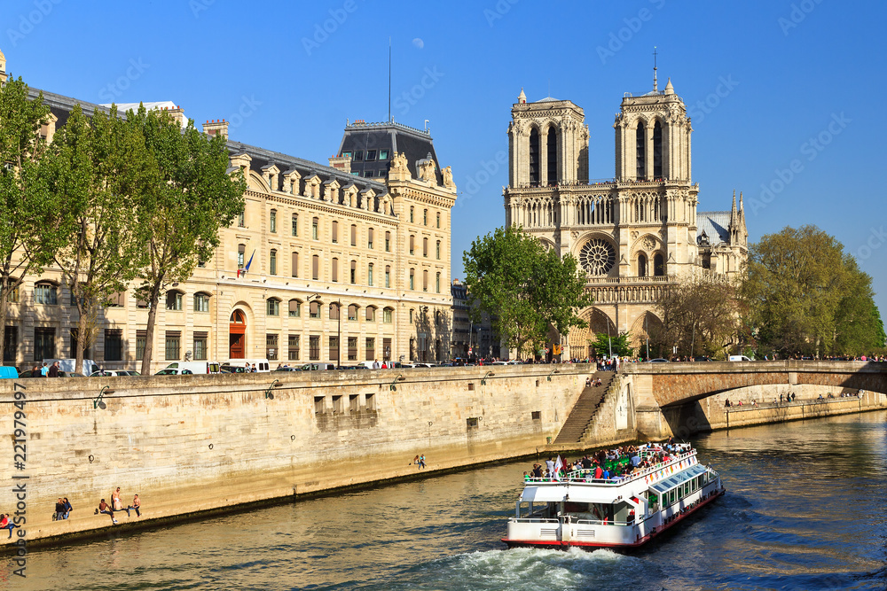 Beautiful view of the river Seine with a canal-boat and the Notre-Dame Cathedral in Paris
