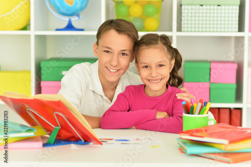 Cute little girl with brother doing homework
