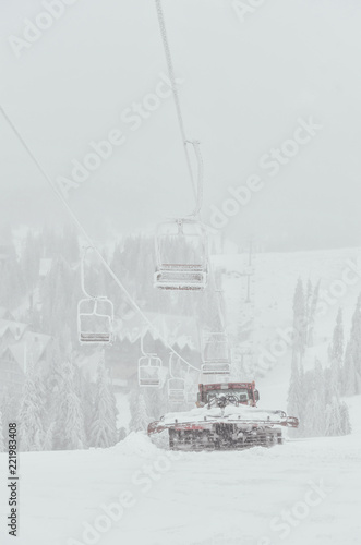 Snowcat preparing a slope in high mountains at skiing resort