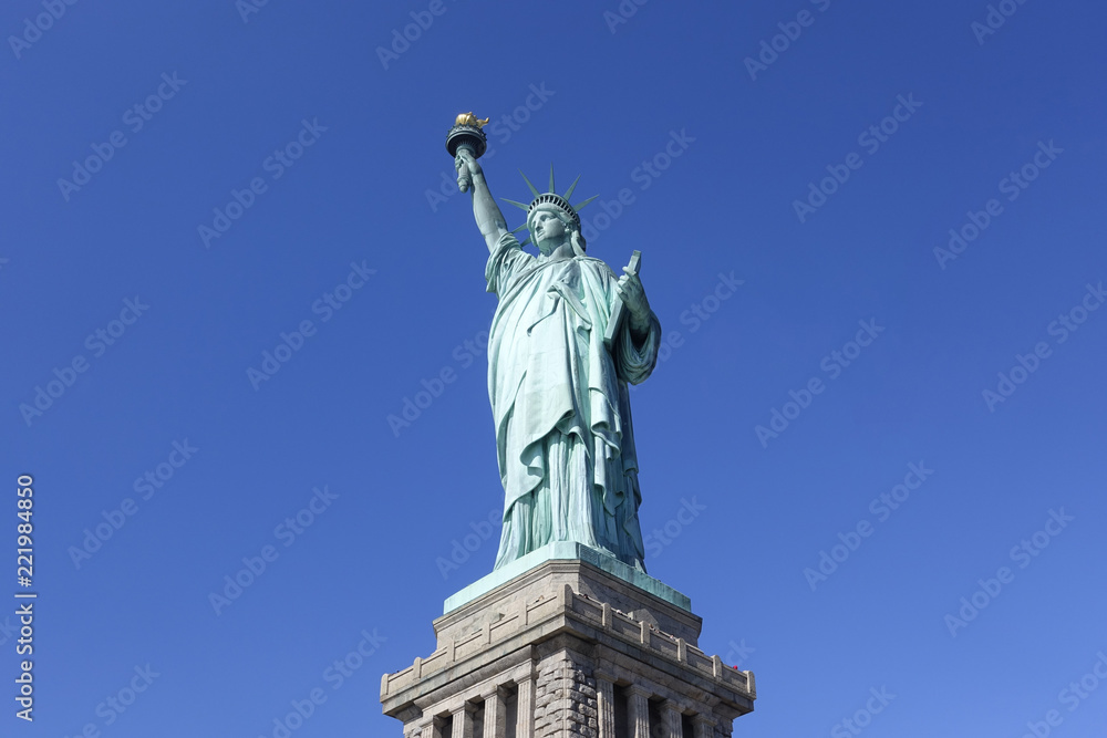 Statue of Liberty iconic landmark and tourist attraction place of New York city NYC USA American symbol stand in clear deep blue sky background of good weather day ant eyes view