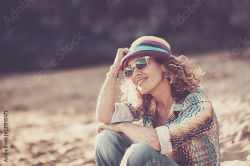 Happy beautiful cheerful caucasian woman middle age sitting at the beach and enjoying the summer time. smile and relax after work. vacation and travel concept with attractive and aged people #221985471