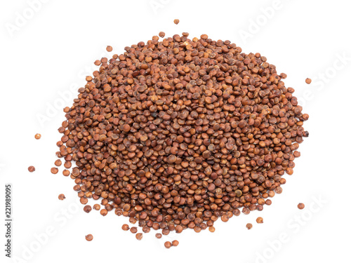 Pile of red quinoa seeds seen obliquely from above and isolated on white background