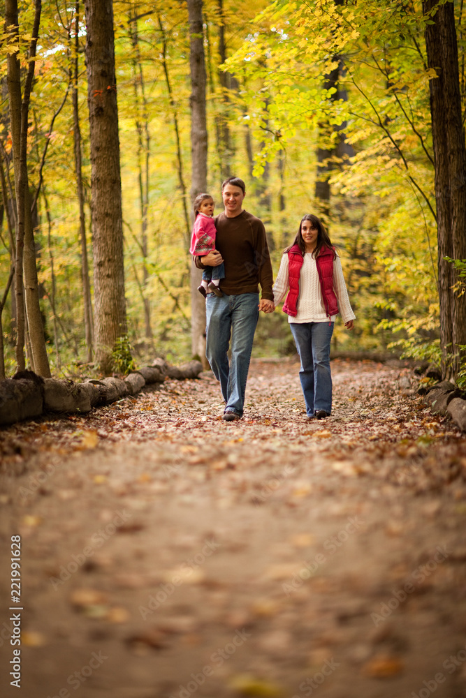 Happy Young Family Walking in Autumn Woods Happy Young Family Walking in Autumn Woods