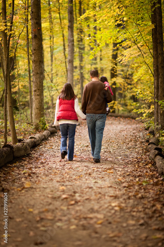 Young Family Walking in Autumn Woods