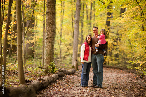 Happy Young Family Standing in Autumn Woods