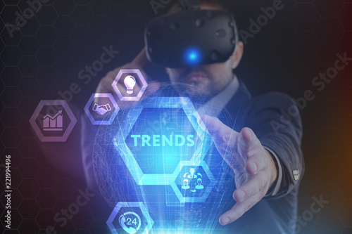 The concept of business, technology, the Internet and the network. A young entrepreneur working on a virtual screen of the future and sees the inscription: Trends